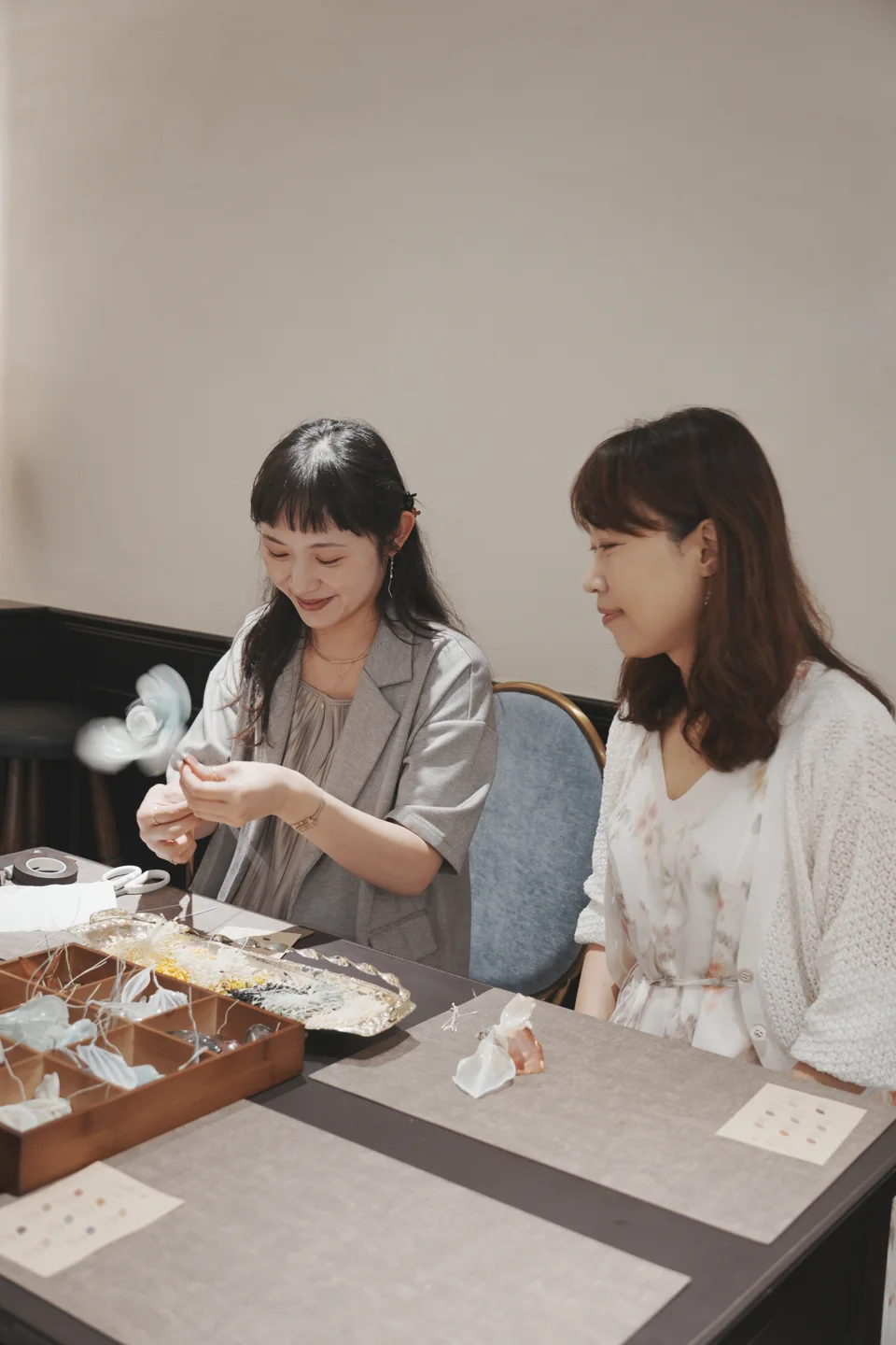 兩位參與者在桌邊交流製作中的花朵
